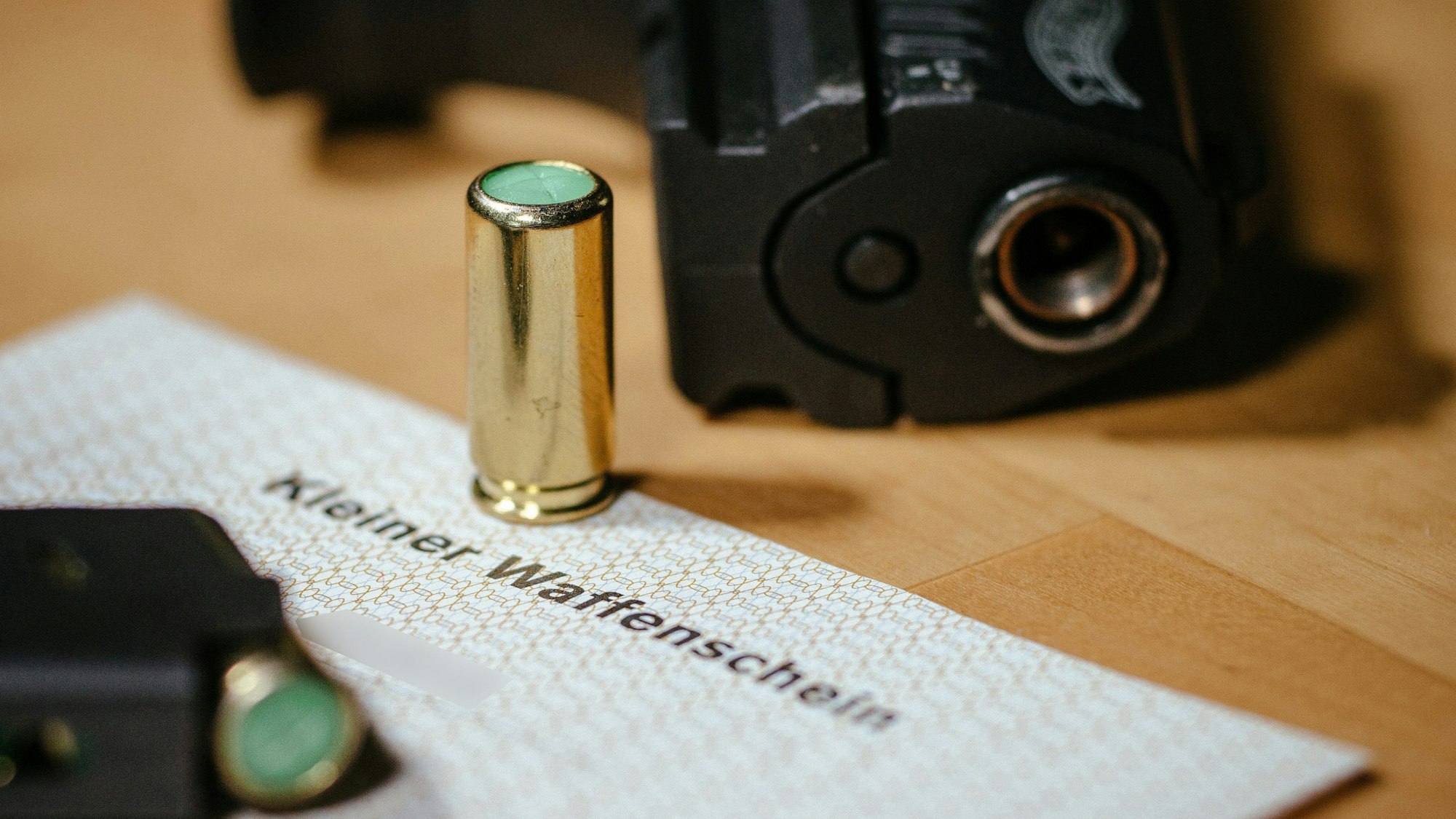 Ein kleiner Waffenschein liegt zwischen einer Schreckschuss-Pistole «Walther P22», einem Magazin und einer Platzpatrone.