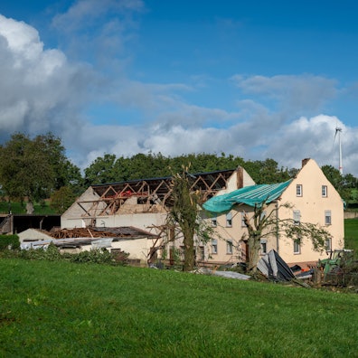Trümmer und Dachteile liegen neben einem Haus im rheinland-pfälzischen Nusbaum. Ein Tornado ist am Donnerstag über die Eifel hinweggezogen.