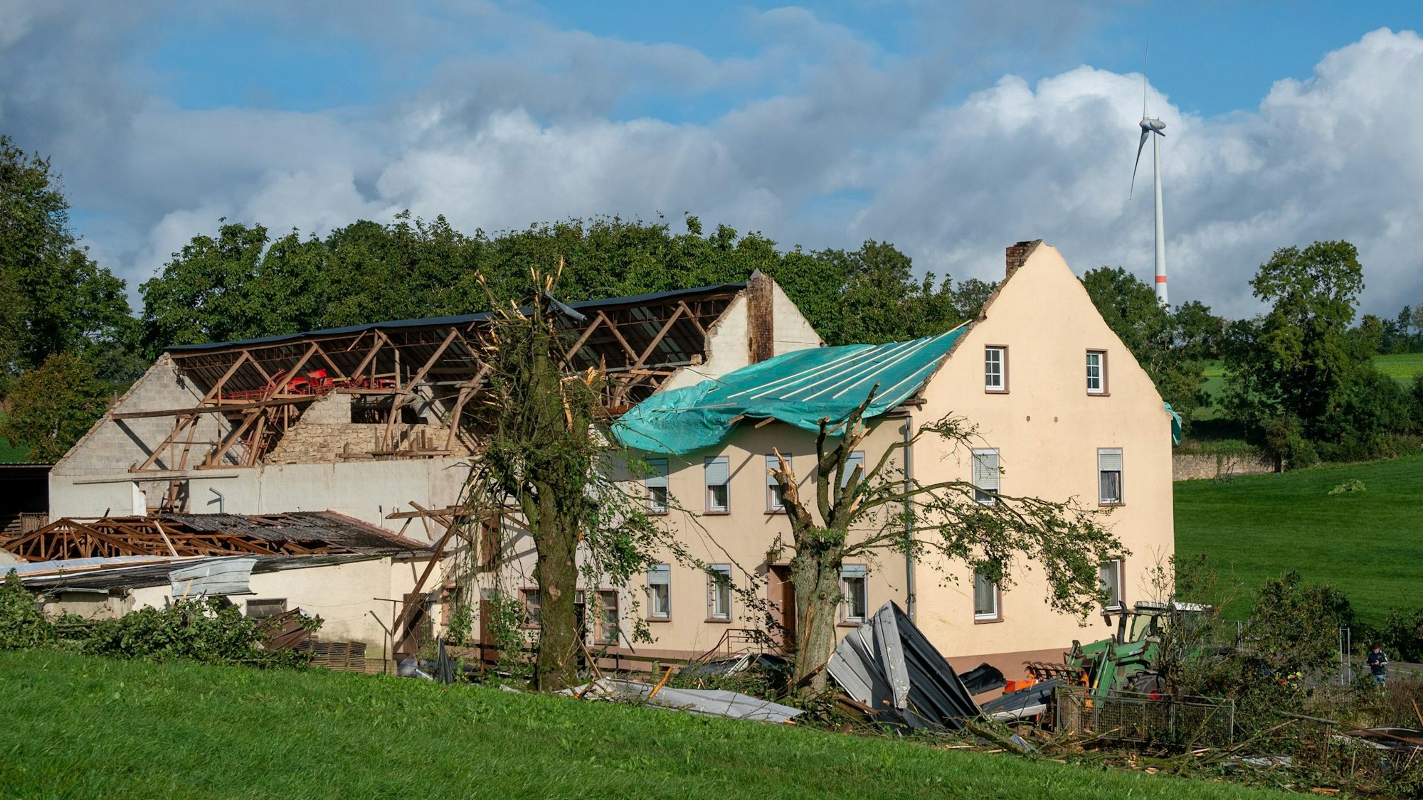 Trümmer und Dachteile liegen neben einem Haus im rheinland-pfälzischen Nusbaum. Ein Tornado ist am Donnerstag über die Eifel hinweggezogen.