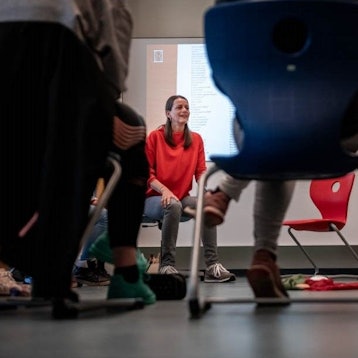 Seidel-Rarreck sitzt in der Malteserschule im Kreis ihrer Schülerinnen und Schüler