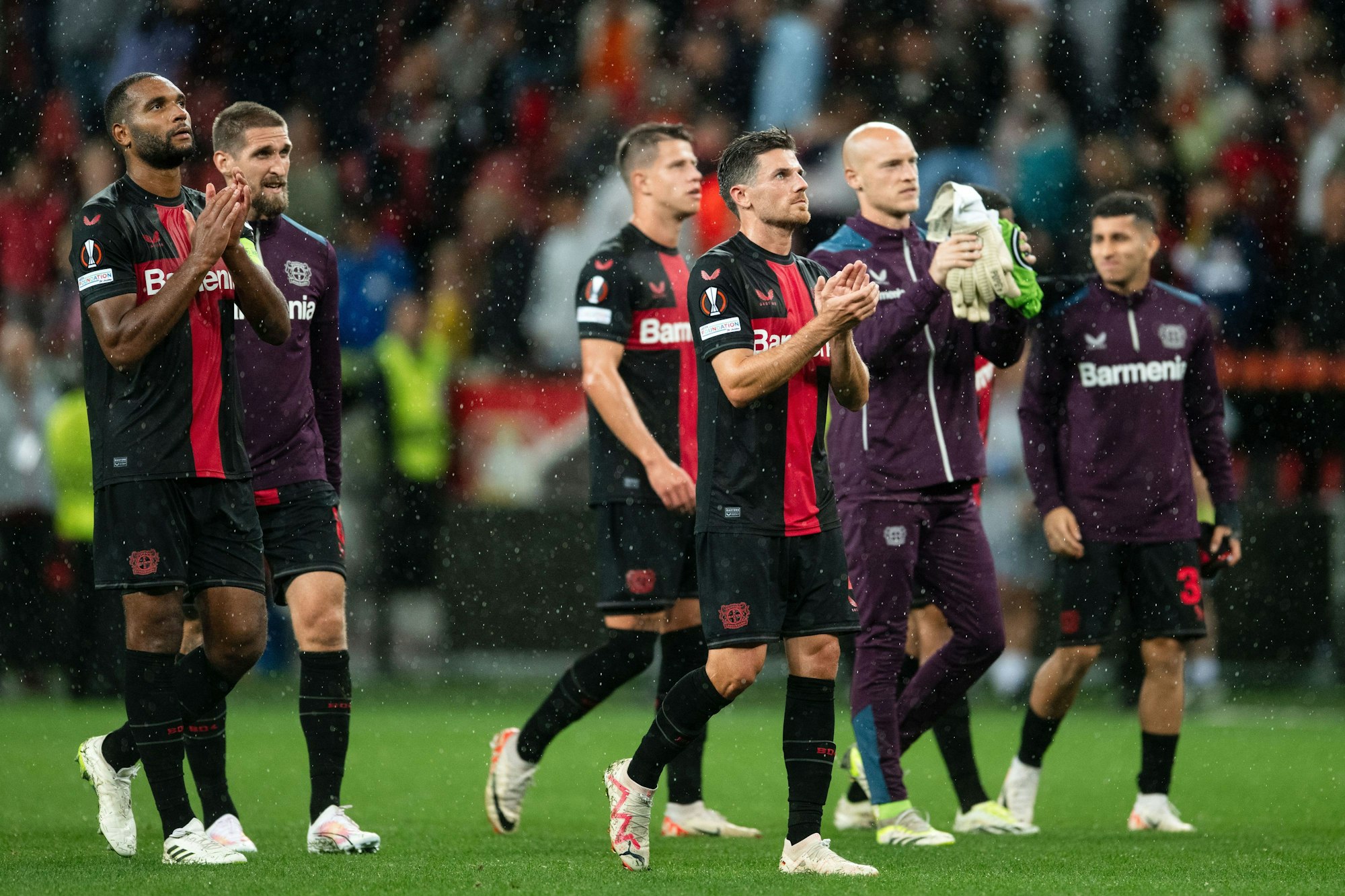 Die Leverkusener Spieler um Jonathan Tah (l.), Robert Andrich (2.v.l.) und Jonas Hofmann (4.v.l.) bedanken sich nach der Partie bei den Fans.