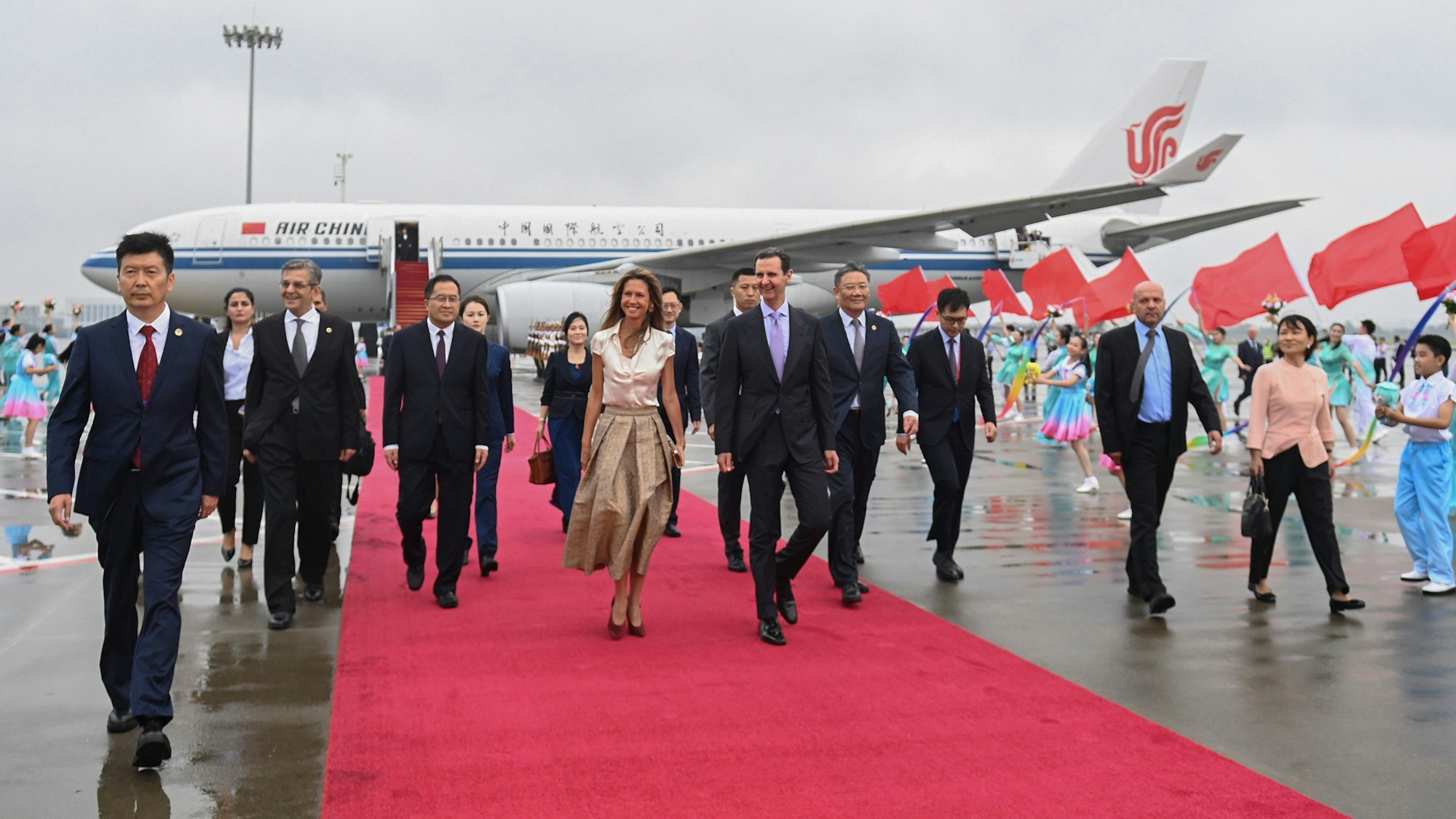 Auf diesem von der Nachrichtenagentur Xinhua veröffentlichten Foto kommen der syrische Präsident Bashar Assad (M r), und die First Lady Asma Assad in Hangzhou, China, an.