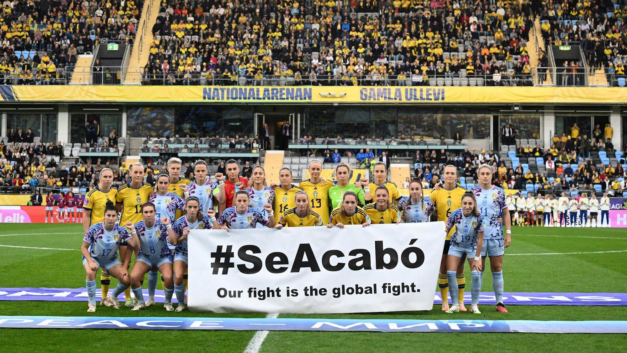 Die schwedische und die spanische Mannschaft halten ein Banner mit der Aufschrift „#SeAcabo - Our fight is the global fight“ (#SchlussDamit - Unser Kampf ist ein globaler Kampf) vor dem Spiel.