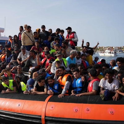Migranten kommen auf einem Schlauchboot im Hafen von Lampedusa an.