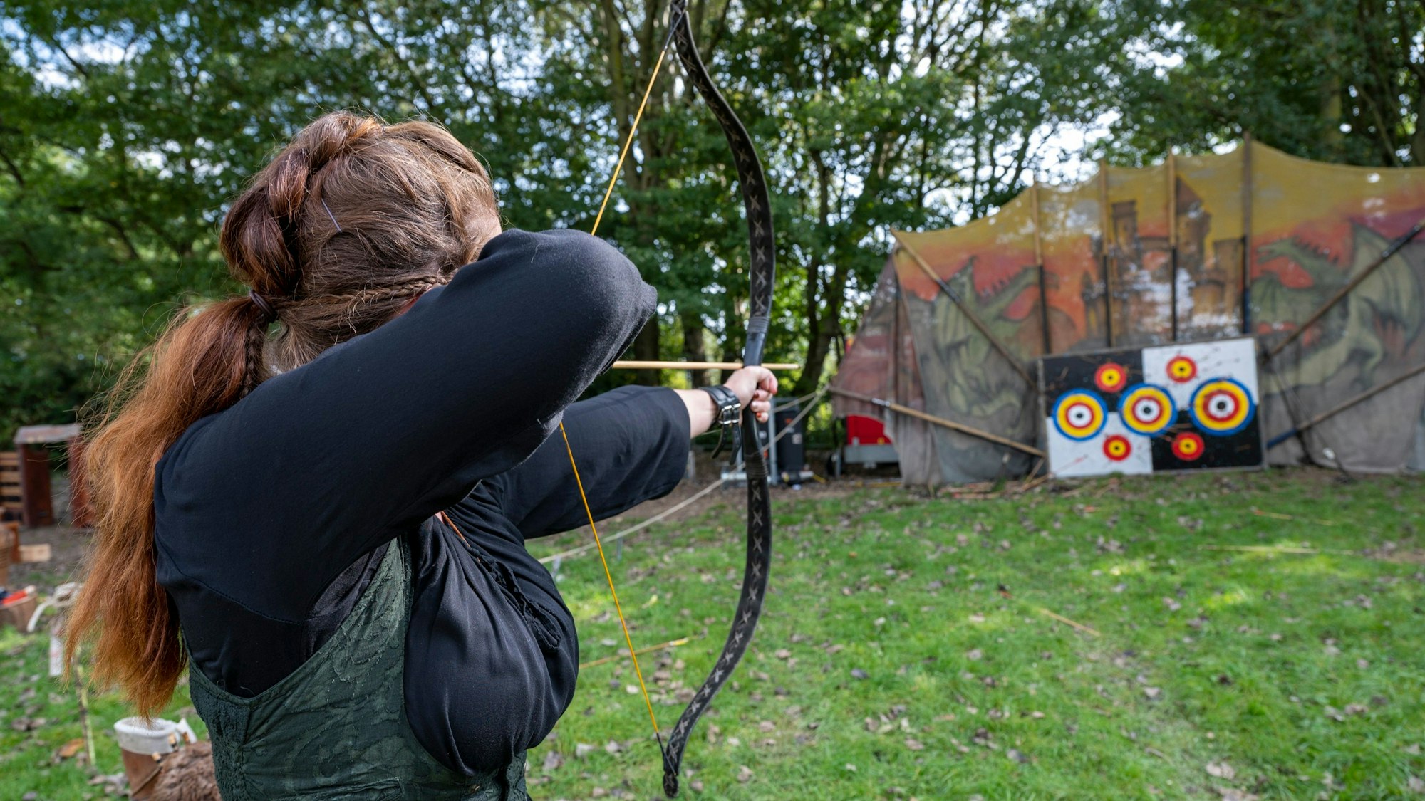 Eine Frau schießt Bogen.