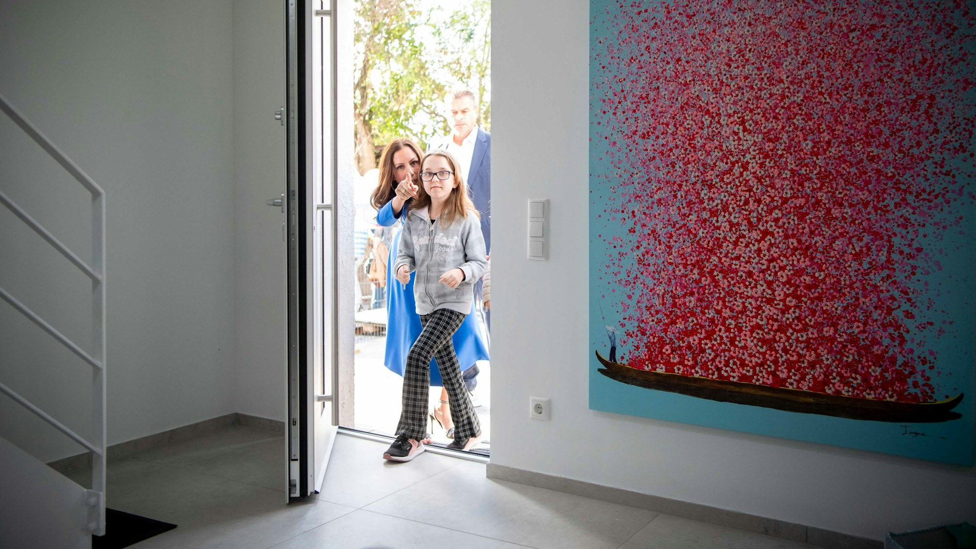 Das Bild zeigt die Zwölfjährige, wie sie mit der Projektleiterin durch die Tür geht.