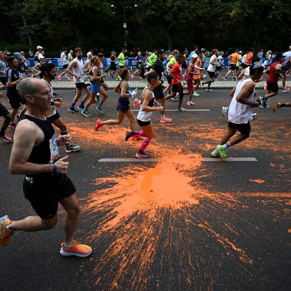 dpatopbilder - 24.09.2023, Berlin: Leichtathletik: Berliner Marathon. Teilnehmer des Marathon laufen durch die orangefarbene Farbe, die von Aktivisten der Klimaschutzgruppe "Letzte Generation" bei einer Protestaktion auf den Asphalt geschüttet wurde. Foto: Sebastian Christoph Gollnow/dpa +++ dpa-Bildfunk +++