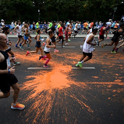 dpatopbilder - 24.09.2023, Berlin: Leichtathletik: Berliner Marathon. Teilnehmer des Marathon laufen durch die orangefarbene Farbe, die von Aktivisten der Klimaschutzgruppe "Letzte Generation" bei einer Protestaktion auf den Asphalt geschüttet wurde. Foto: Sebastian Christoph Gollnow/dpa +++ dpa-Bildfunk +++