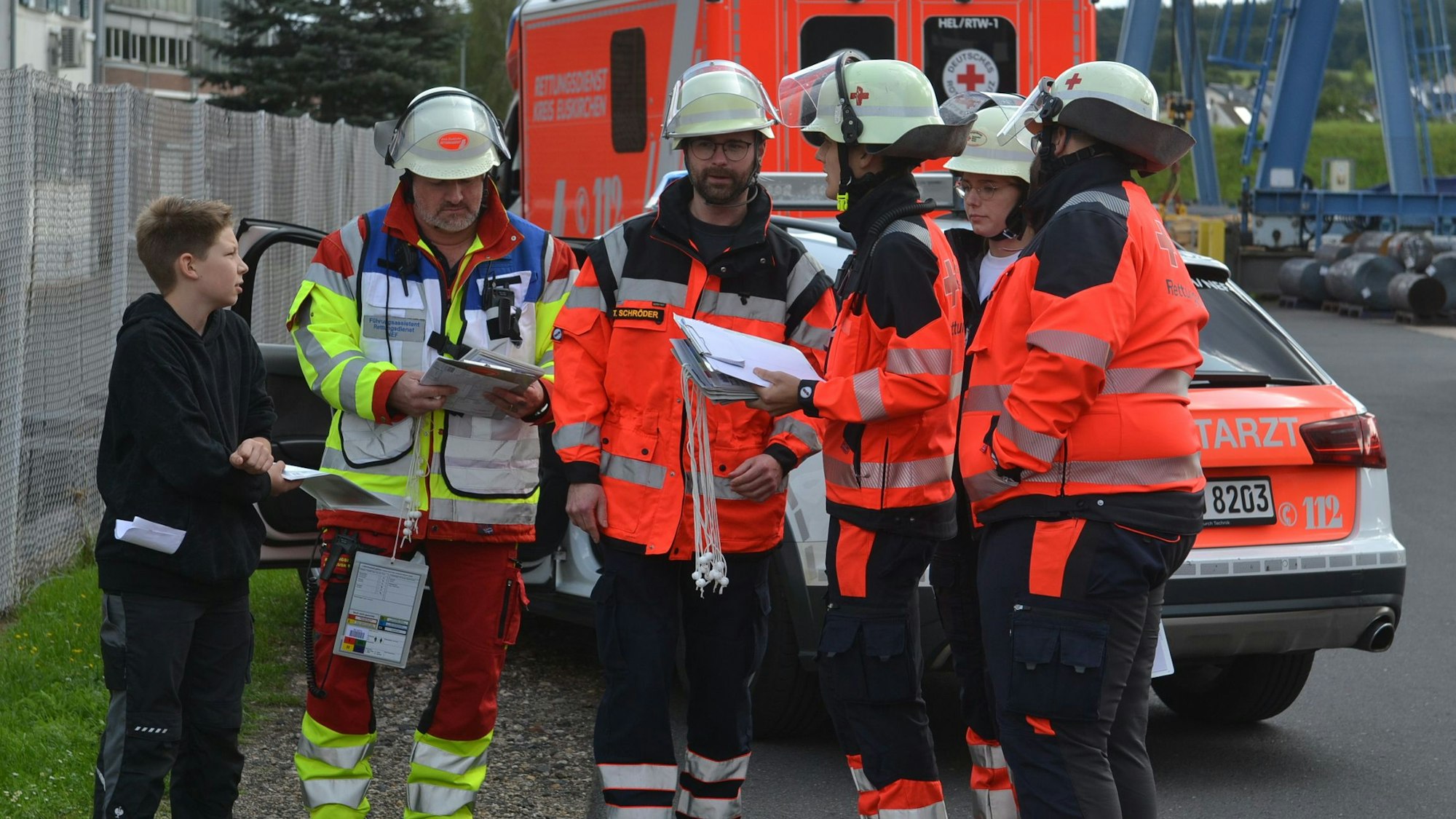 Das Bild zeigt einige Einsatzkräfte und einen jungen Verletztendarsteller.