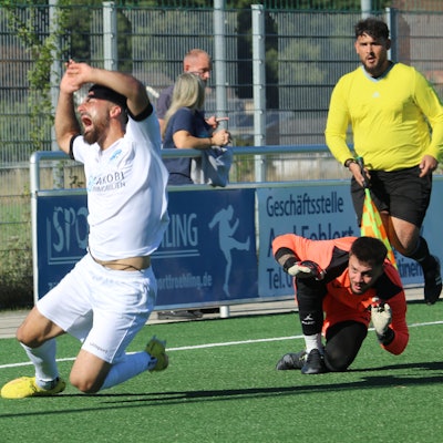 Bessenichs Stürmer fällt und schreit. Der Wesselinger Torhüter hat ihn getroffen.
