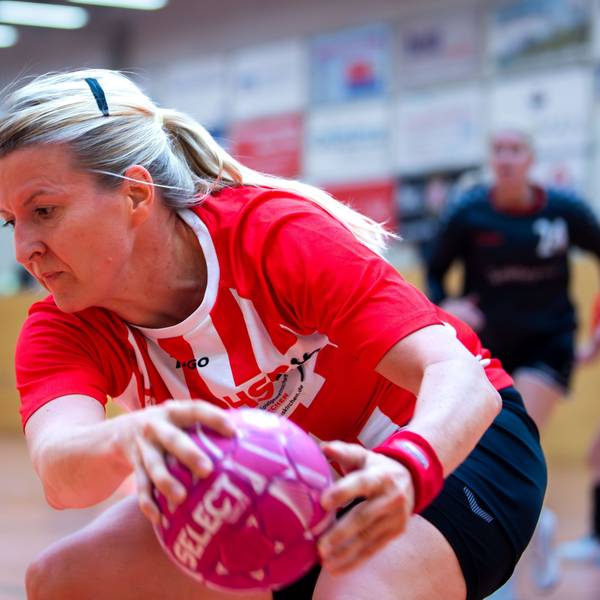 Eine Handballspielerin sich sich den Ball.