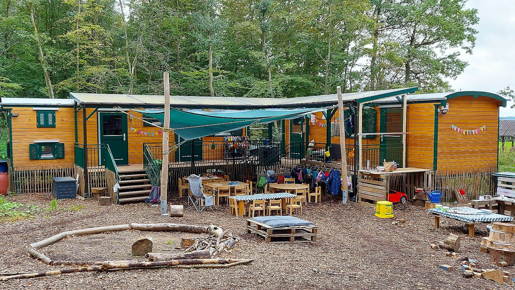 Das Bild zeigt einen Waldkindergarten mit Wichtelwagen.