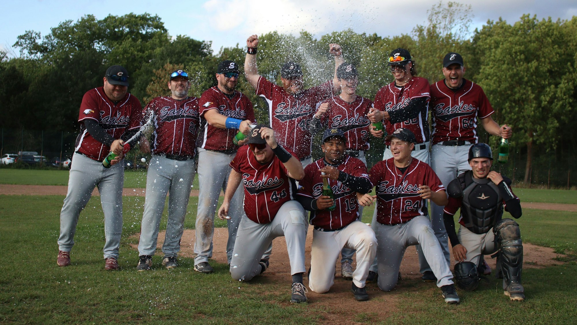 Eine Baseballmannschaft jubelt und lässt den Sekt spritzen.