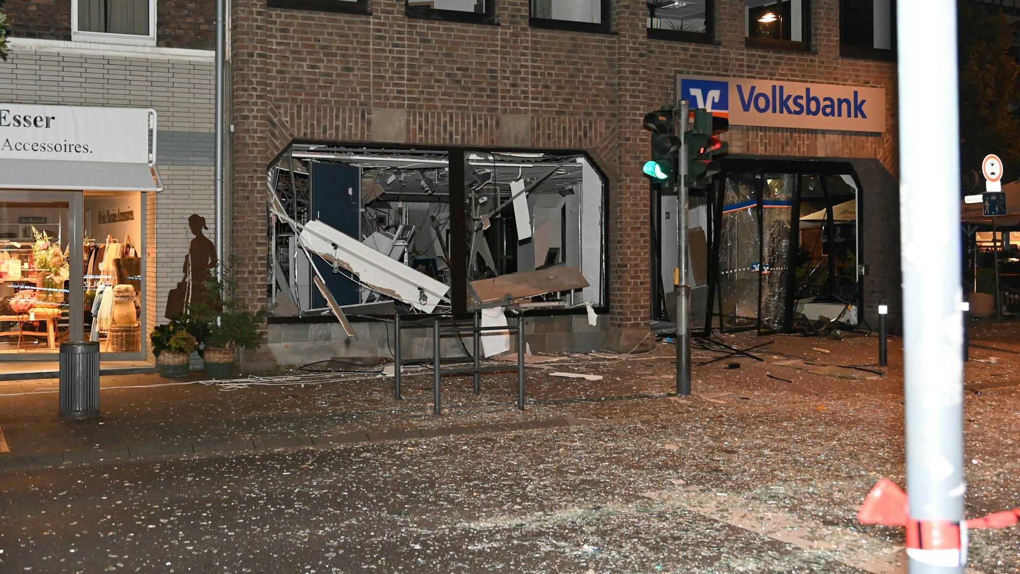 Scherben liegen auf der Straße. Die Volksbank hat zerstörte Scheiben.