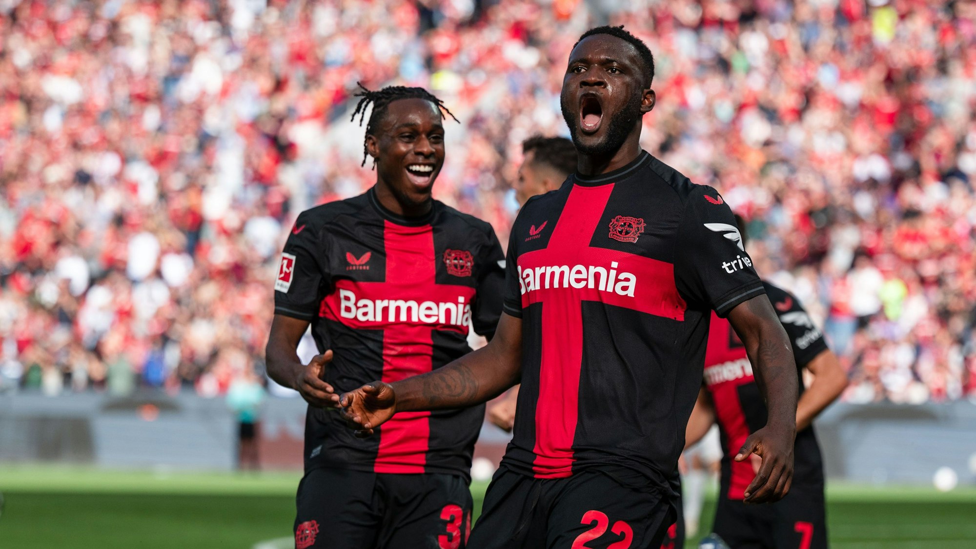 Leverkusens Torschütze Victor Boniface (r) und Jeremie Frimpong jubeln nach dem Treffer zur 1:0 Führung.