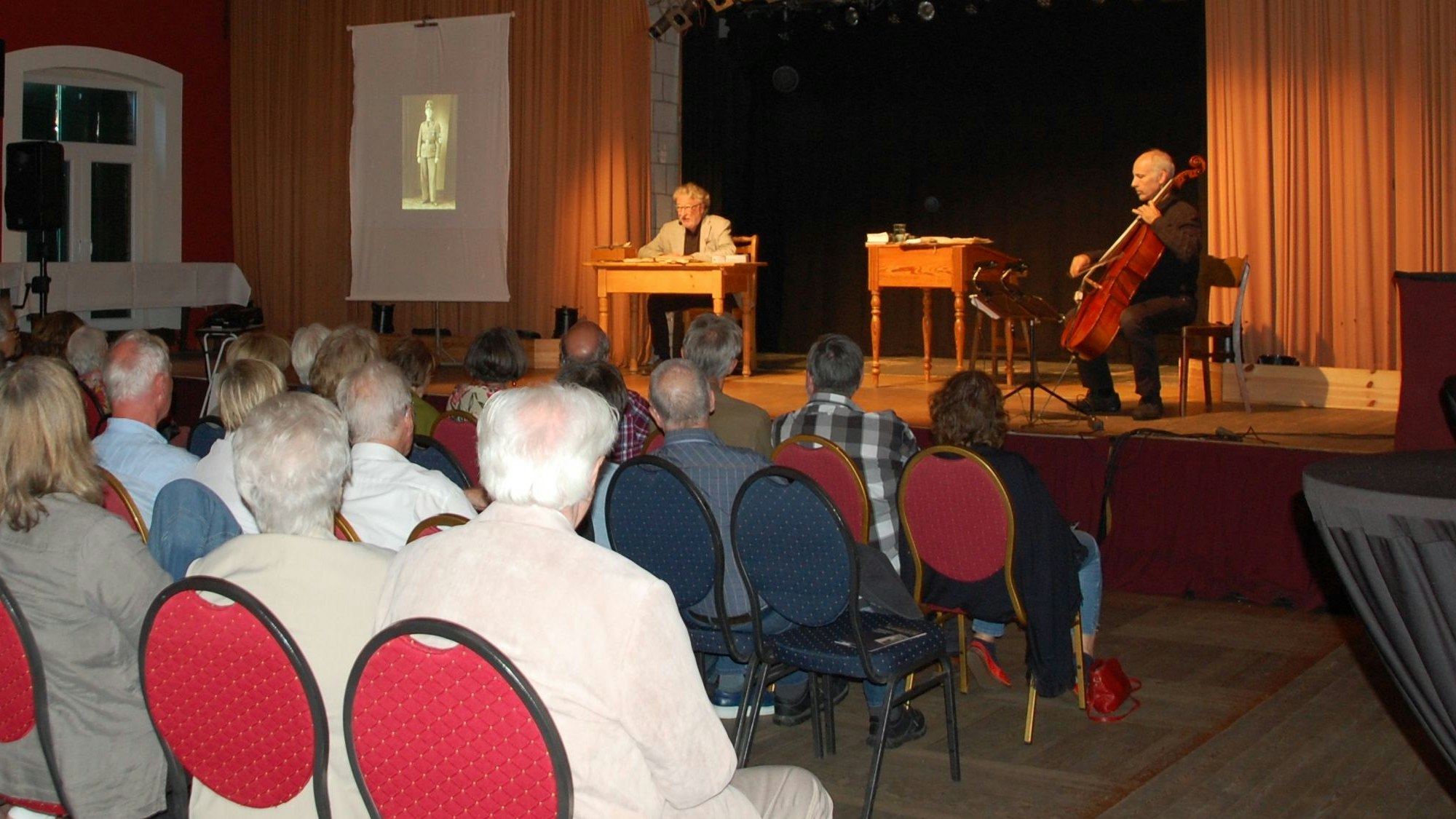 Heinz-D. Haun liest auf der Bühne des Saals Norhausen aus seinem szenischen Hörspiel.
