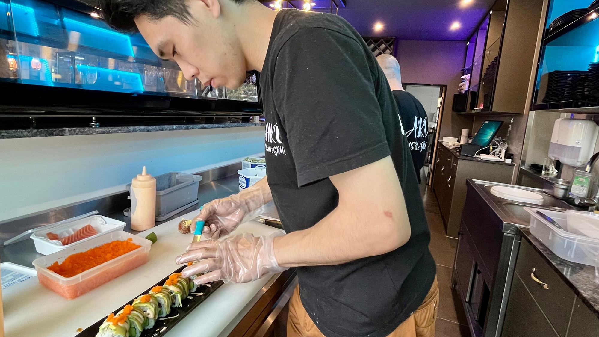 Mann stellt Sushi her.