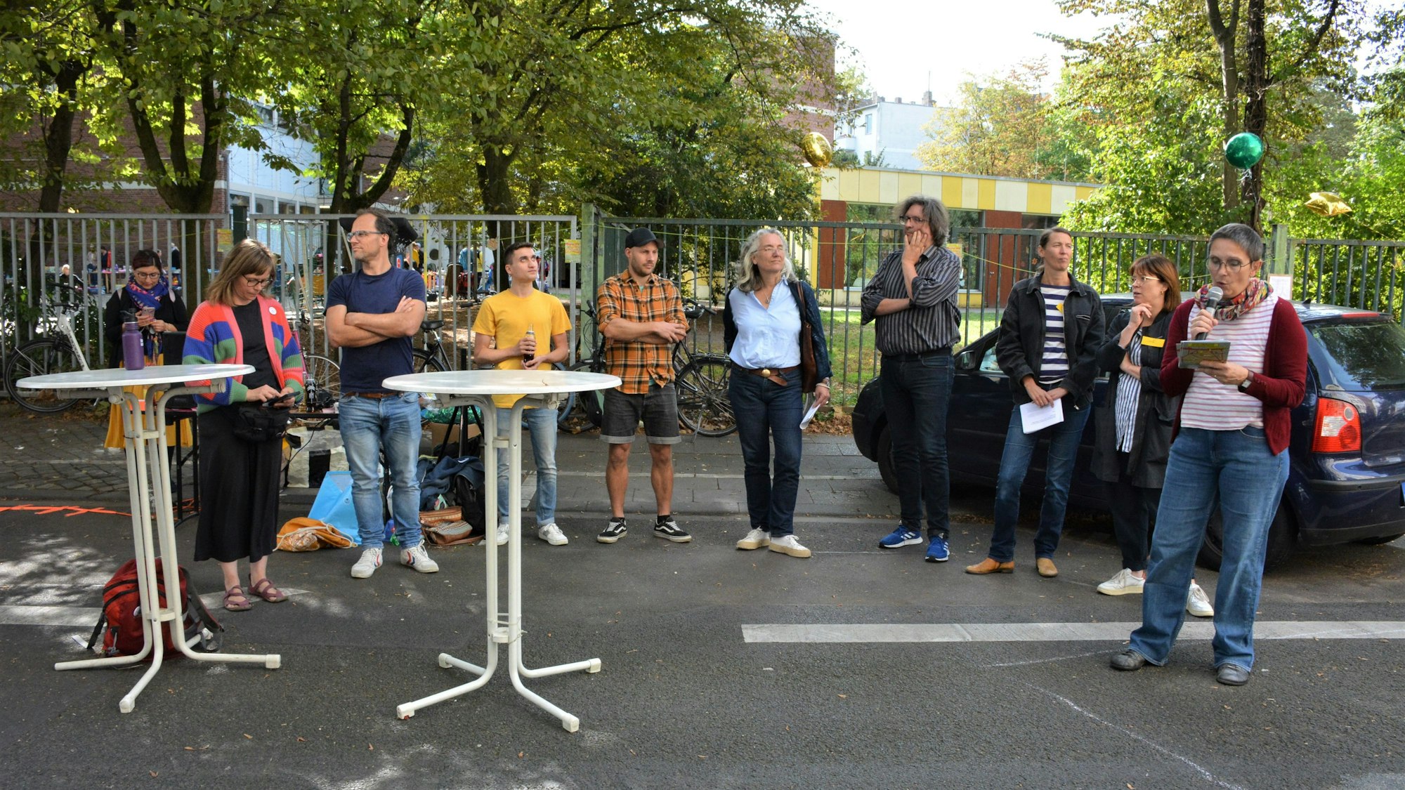 Neun Menschen stehen auf der Burgunderstraße und diskutieren.