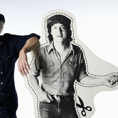 Wolfgang Niedecken steht neben einem Pappaufsteller, der ihn in jungen Jahren zeigt.