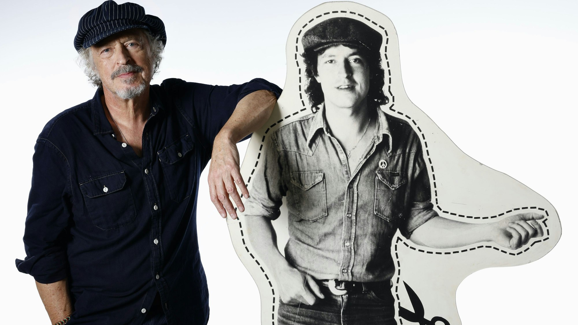 Wolfgang Niedecken steht neben einem Pappaufsteller, auf dem der junge Niedecken zu sehen ist.