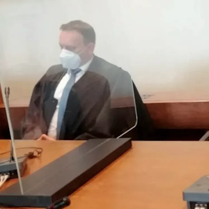 Das Foto zeigt Alinas Mutter während des Prozesses 2021. Neben ihr sitzt einer ihrer Verteidiger.