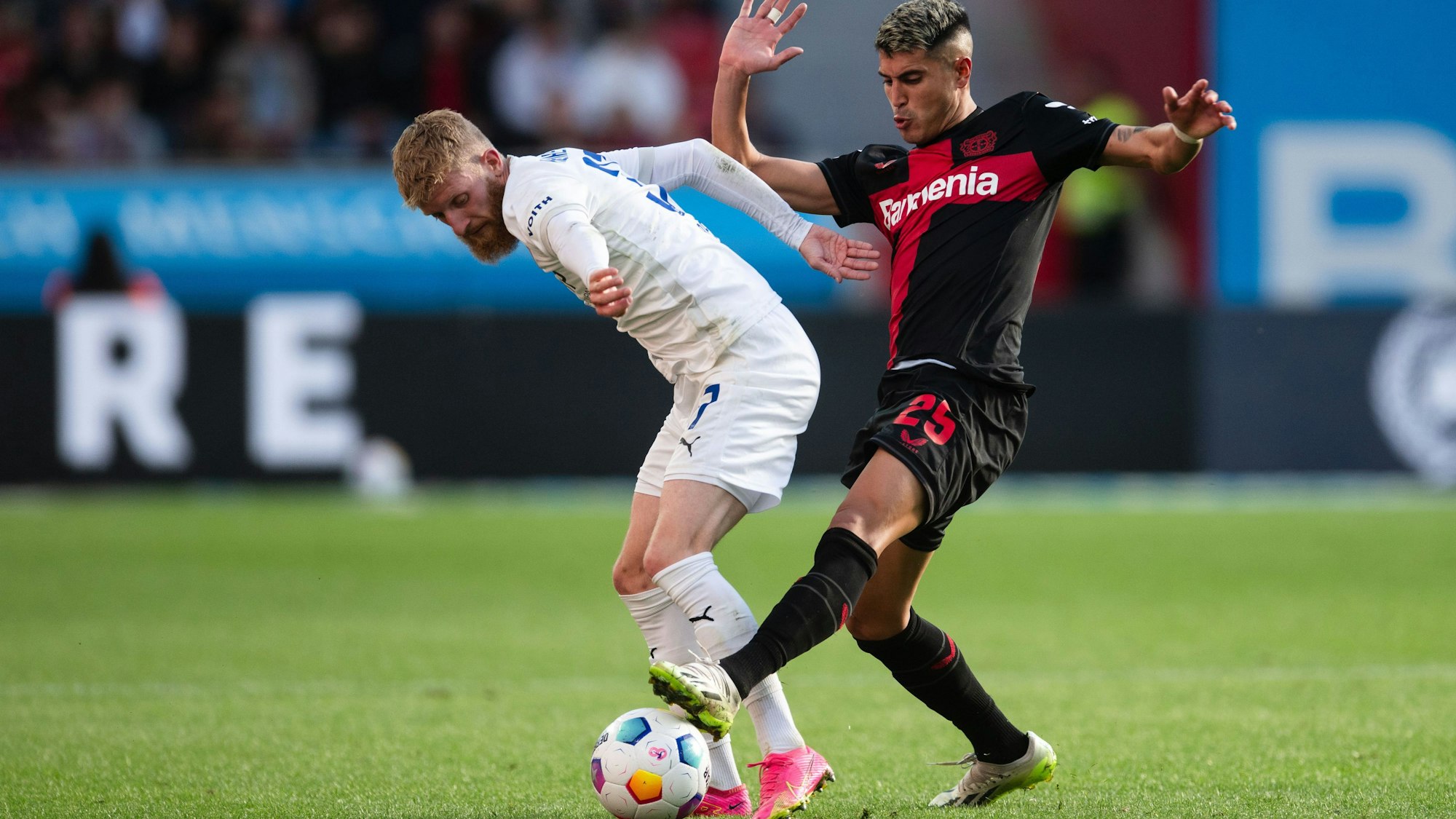 Leverkusens Exequiel Palacios und Heidenheims Jan-Niklas Beste kämpfen um den Ball.