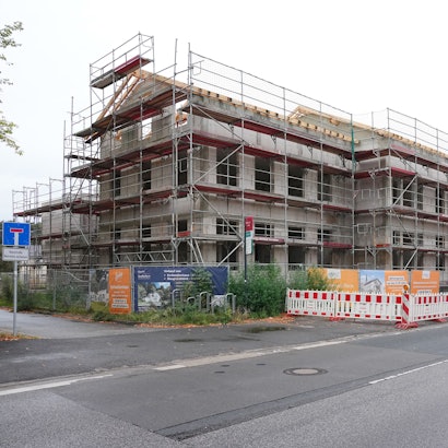 Ein Baugerüst steht an dem Rohbau eines Mehrfamilienhauses im Potsdamer Ortsteil Bornim. Wie findet Deutschland wieder Wohnraum? Um diese Frage geht es am Montag im Kanzleramt.