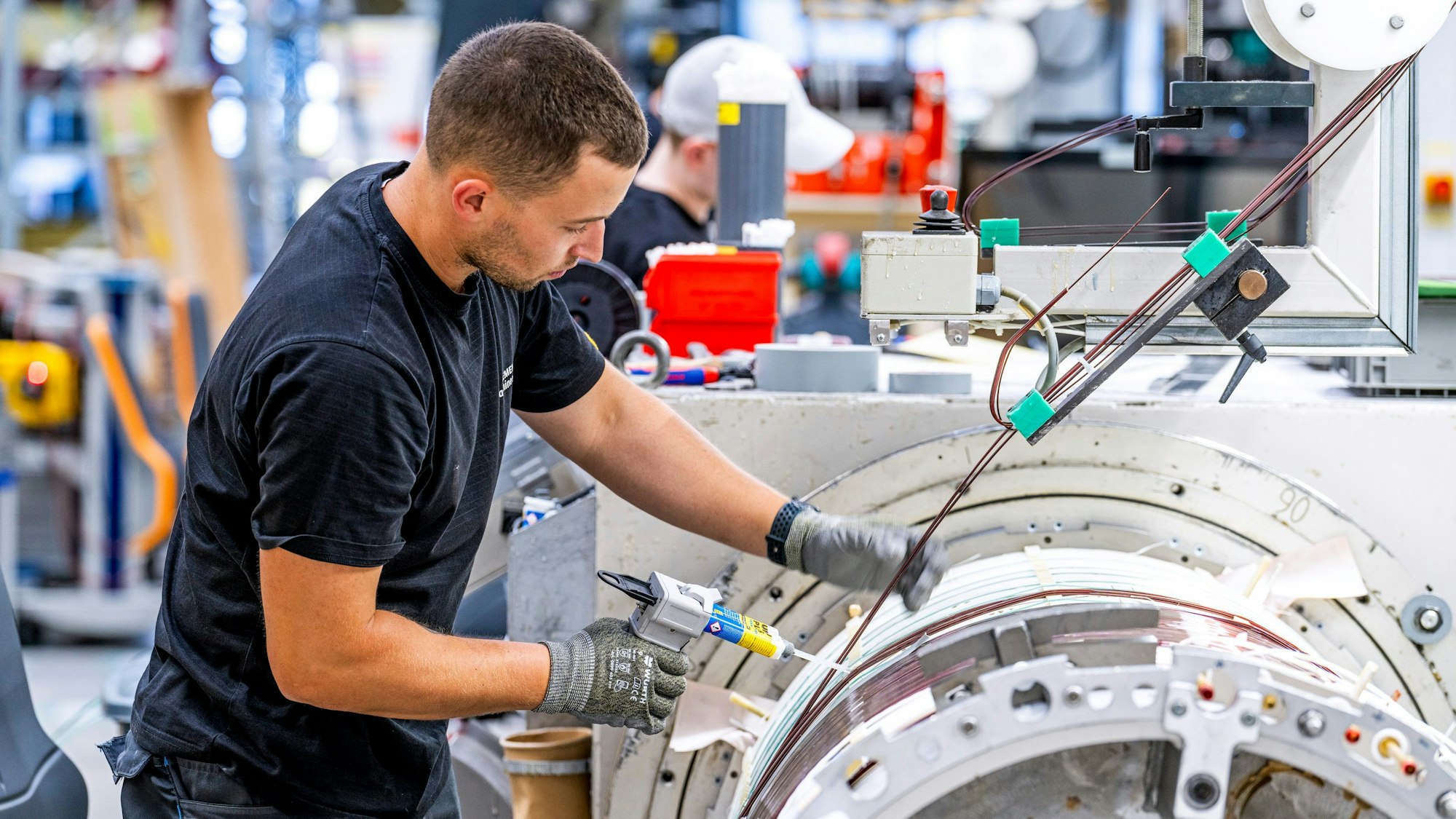 Ein Mann arbeitet bei der Fertigung der Gradientenspule zu einem Magnetresonanztomographie-Gerät in Erlangen (undatierte Aufnahme). Erlanger Forschende der Siemens Healthineers AG und des Universitätsklinikums Erlangen haben ein Magnetresonanztomographie-Gerät entwickelt, das bei gleicher Bildqualität leichter und günstiger ist und in einigen teils ärmeren Ländern eingesetzt wird. Klimawandel und CO2-Ersparnis, aber auch mehr Effizienz unter anderem durch KI in der Medizin: Mit diesen Zukunftsthemen gehen drei Projekte in den Wettbewerb um den diesjährgigen renommierten Deutschen Zukunftspreis des Bundespräsidenten.