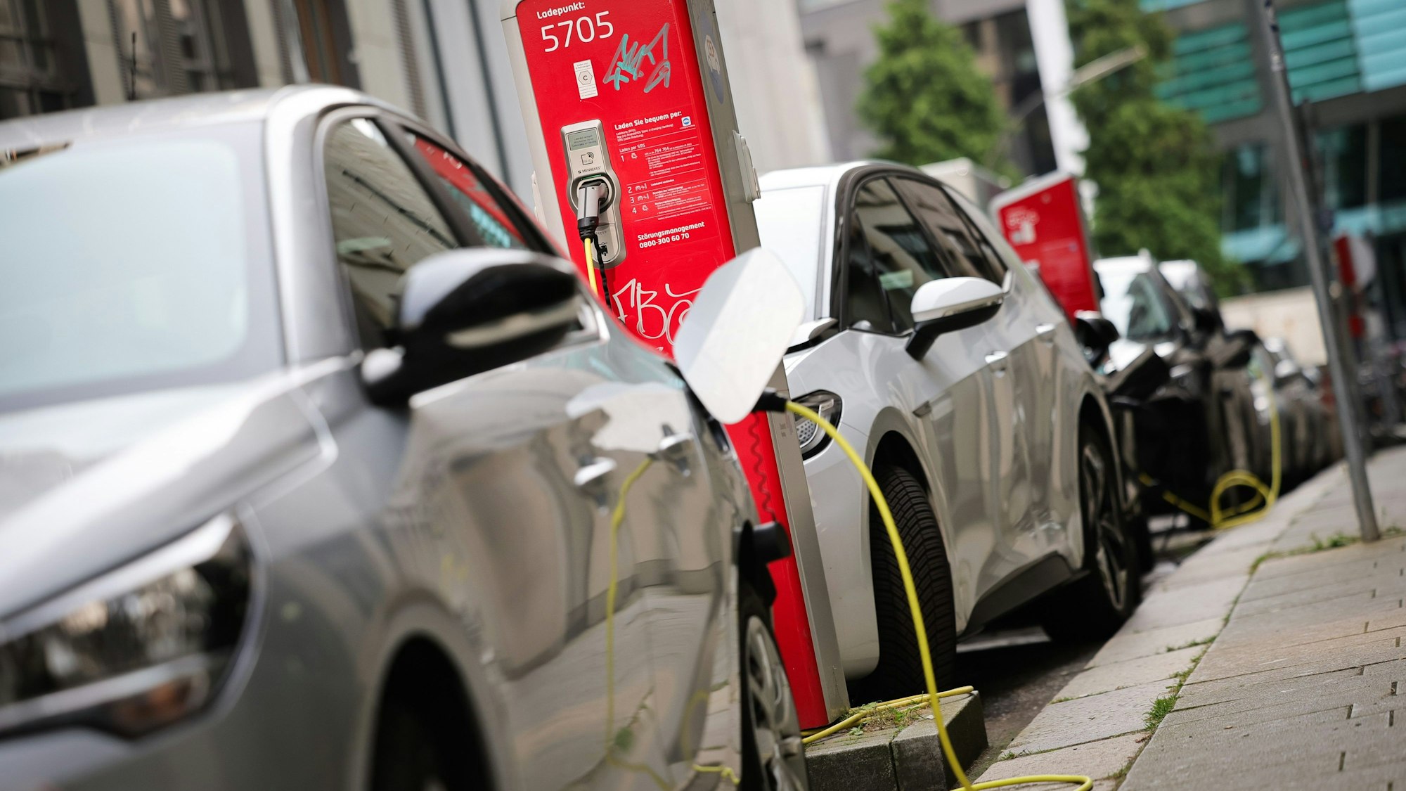 Elektrofahrzeuge werden an einer Ladesäule in der Innenstadt geladen.