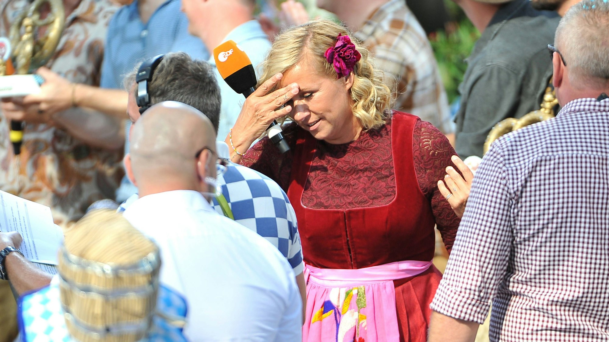 Moderatorin Andrea Kiwi Kiewel während der ZDF - Unterhaltungsshow Fernsehgarten greift sich an den Kopf.