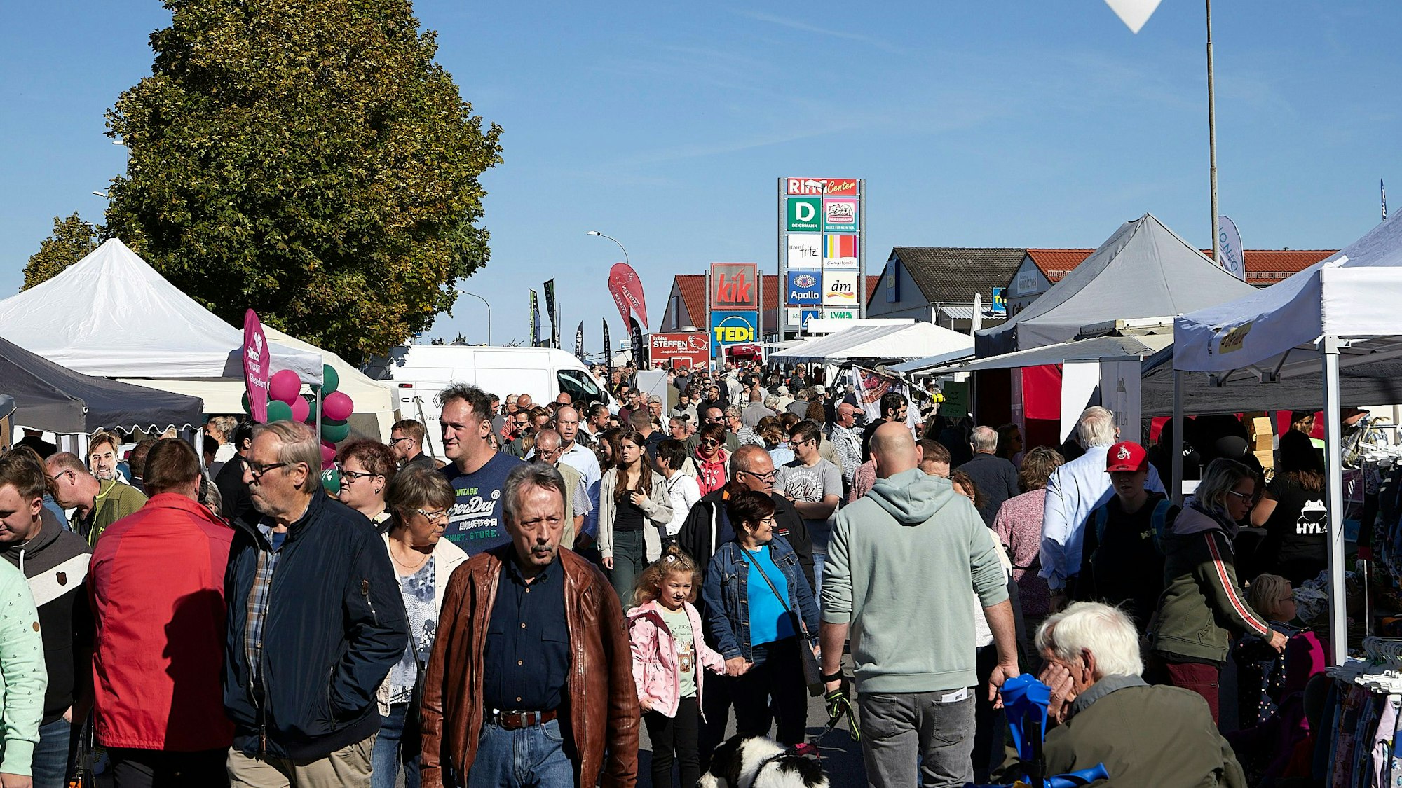 Eine Menschenmenge zieht an den Ständen und Zelten vorbei.
