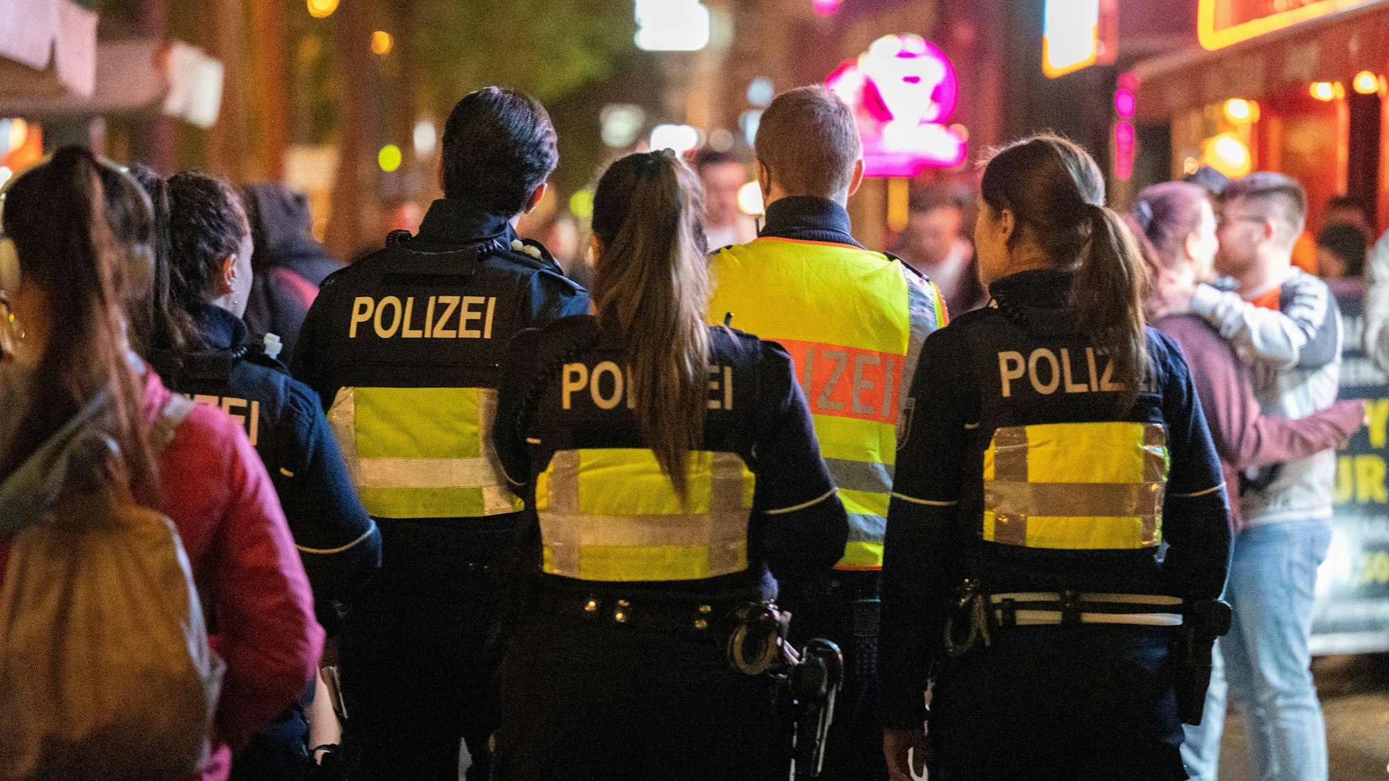 Die Polizei geht nachts durch eine Menschenmenge auf dem Hohenzollernring.