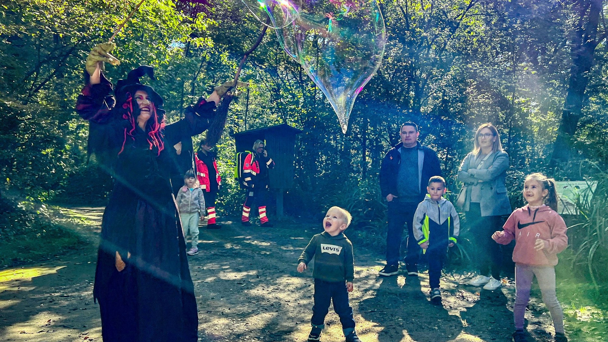 Eine Hexe verzaubert Kinder mit risigen Seifenblasen
