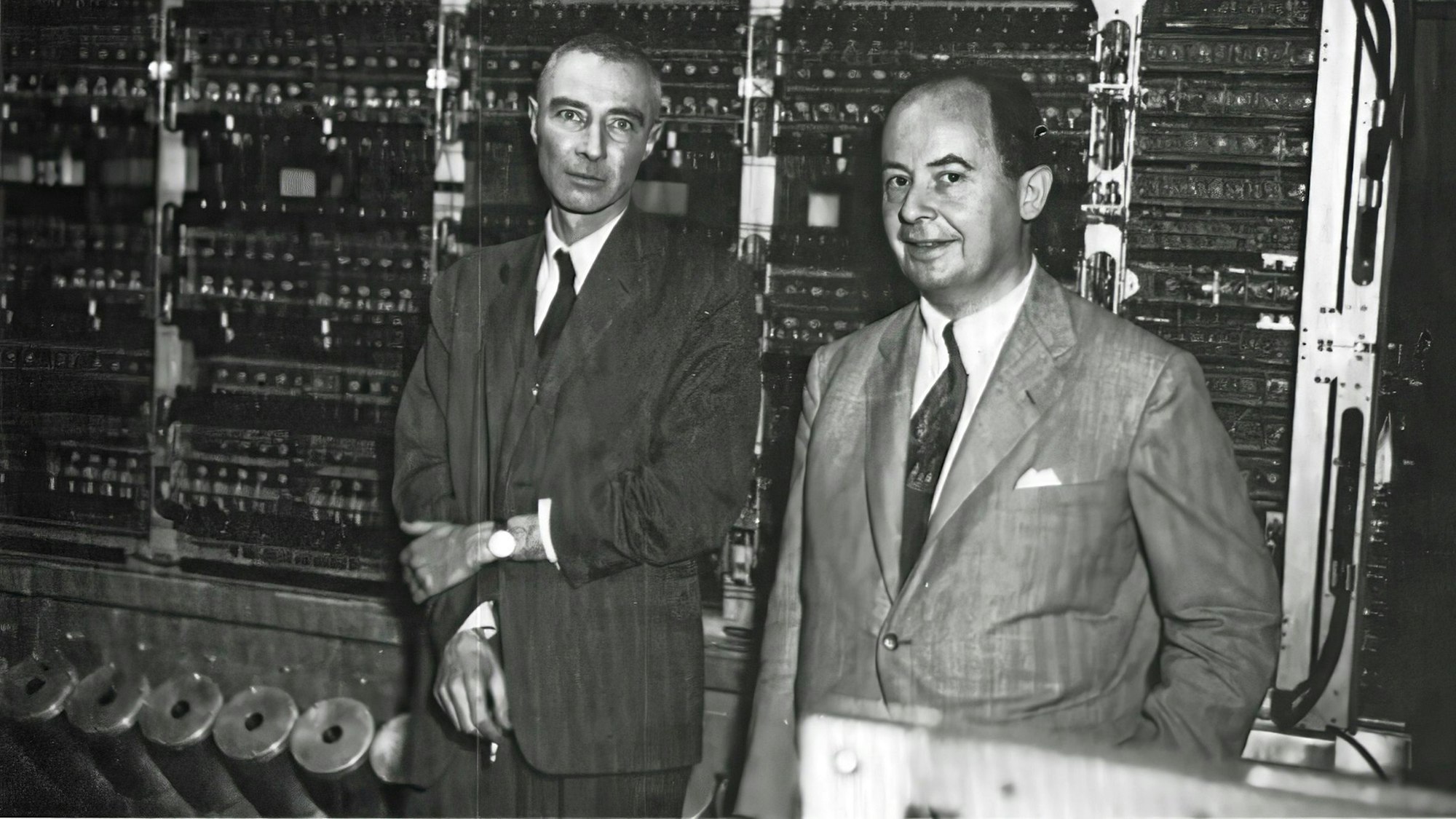 Robert Oppenheimer (links, mit Zigarette in der Hand) und John von Neumann stehen vor dem frühen Universalrechner „MANIAC“ im Keller des Institute for Advanced Study in Princeton.