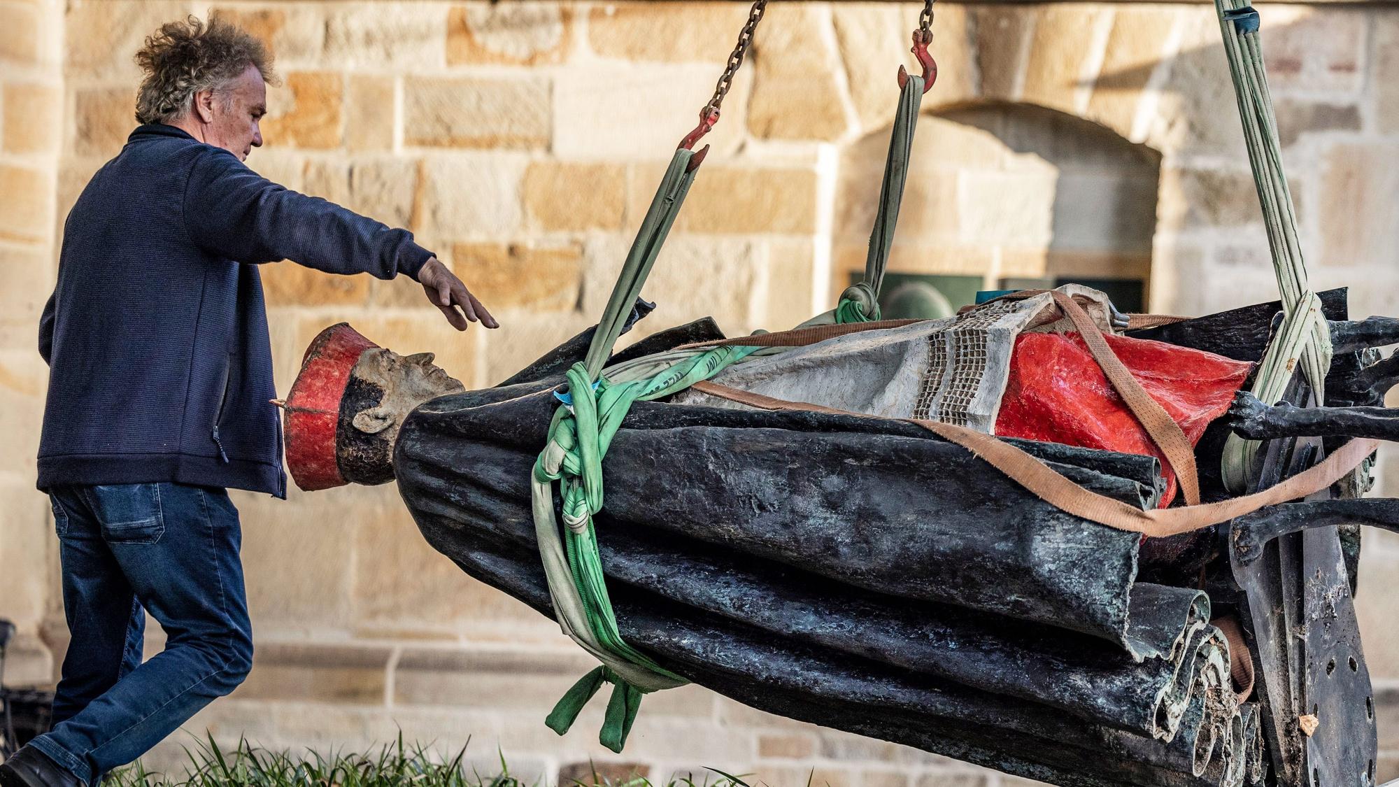 dpatopbilder - 25.09.2023, Nordrhein-Westfalen, Essen: Die Skulptur des Essener Kardinals Franz Hengsbach hängt nach der Demontage vor dem Essener Dom an einem Kran und wird verladen. Das Bistum Essen hatte mitgeteilt, dass der «gravierende» Verdacht bestehe, Hengsbach könnte in seiner Zeit als Weihbischof in Paderborn eine 16-Jährige sexuell missbraucht haben. - recrop Foto: Christoph Reichwein/dpa +++ dpa-Bildfunk +++