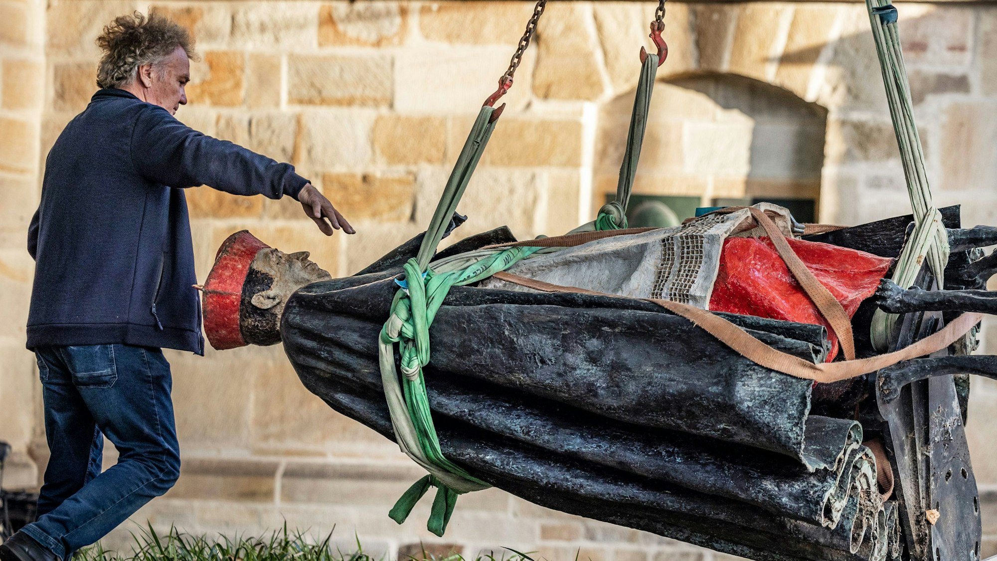 dpatopbilder - 25.09.2023, Nordrhein-Westfalen, Essen: Die Skulptur des Essener Kardinals Franz Hengsbach hängt nach der Demontage vor dem Essener Dom an einem Kran und wird verladen. Das Bistum Essen hatte mitgeteilt, dass der «gravierende» Verdacht bestehe, Hengsbach könnte in seiner Zeit als Weihbischof in Paderborn eine 16-Jährige sexuell missbraucht haben. - recrop Foto: Christoph Reichwein/dpa +++ dpa-Bildfunk +++