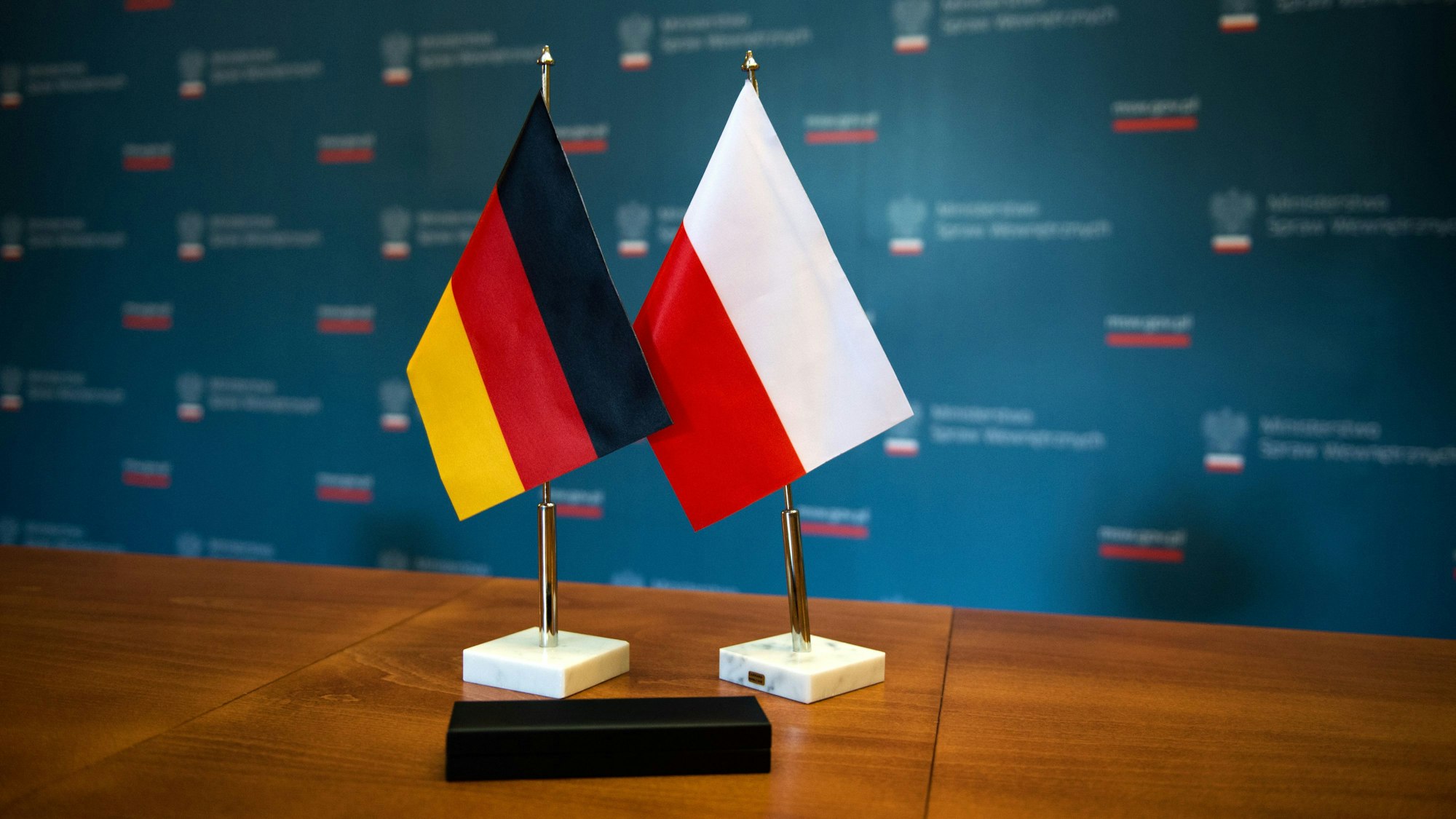 ILLUSTRATION - Nach der Unterzeichnung des Abkommens zwischen der Bundesrepublik Deutschland und der Republik Polen über die Zusammenarbeit der Polizei-, Grenz- und Zollbehörden durch den deutschen Botschafter in Polen und dem deutschen,- sowie den polnischen Innenministern, stehen am 15.05.2014 ein deutsches und eine polnisches Fähnchen auf dem Tisch der Unterzeichnung im Kulturhaus in Zgorzelec (Polen). Foto: Arno Burgi/dpa ++ +++ dpa-Bildfunk +++