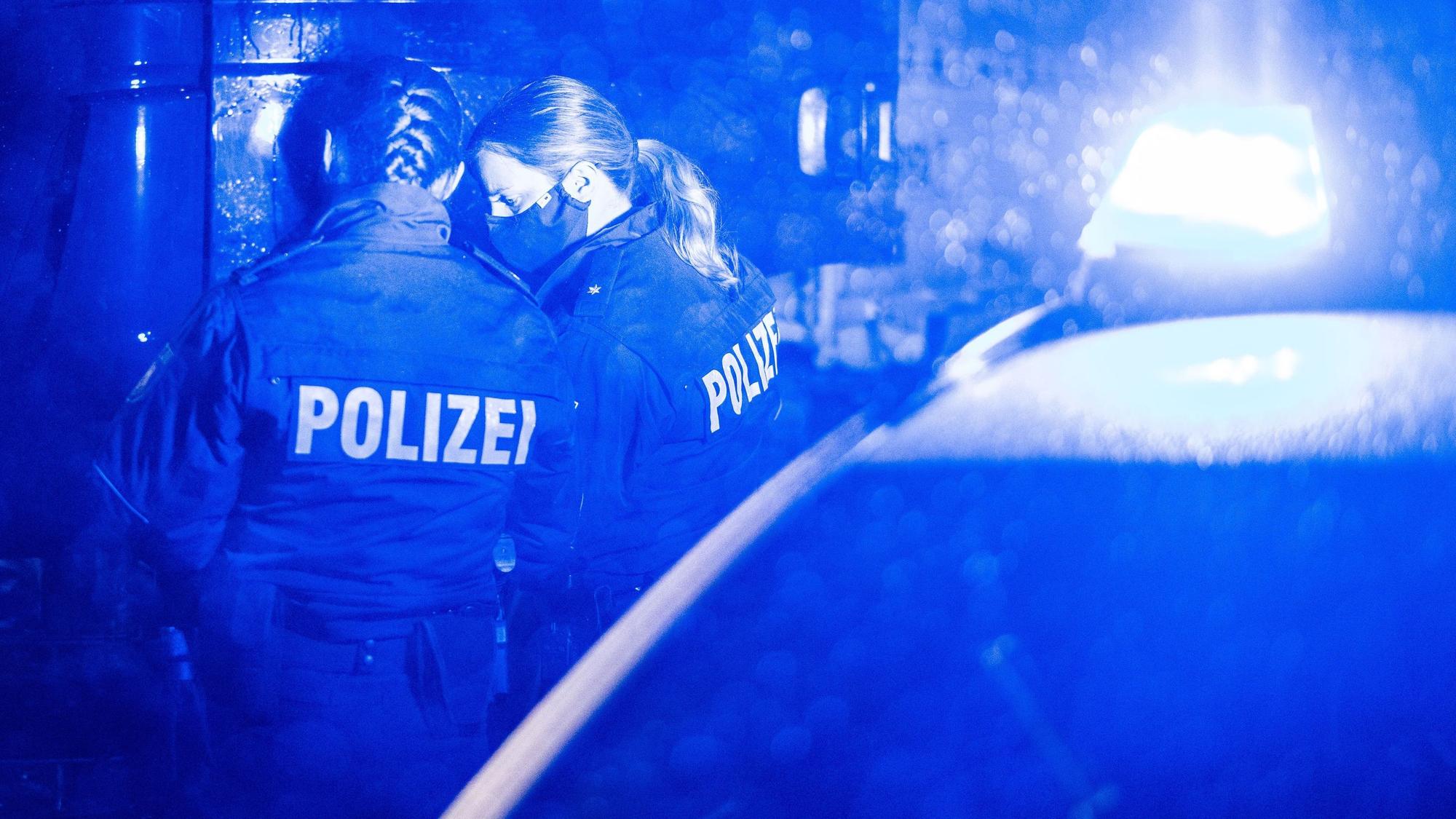 Polizisten kontrollieren einen LKW an einer Autobahn-Kontrollstelle.