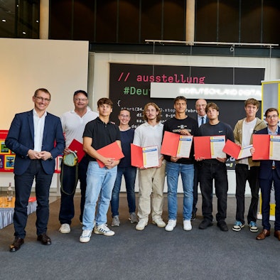 Eine Gruppe von Schülern und Lehrern mit Urkunden im Haus der Geschichte.
