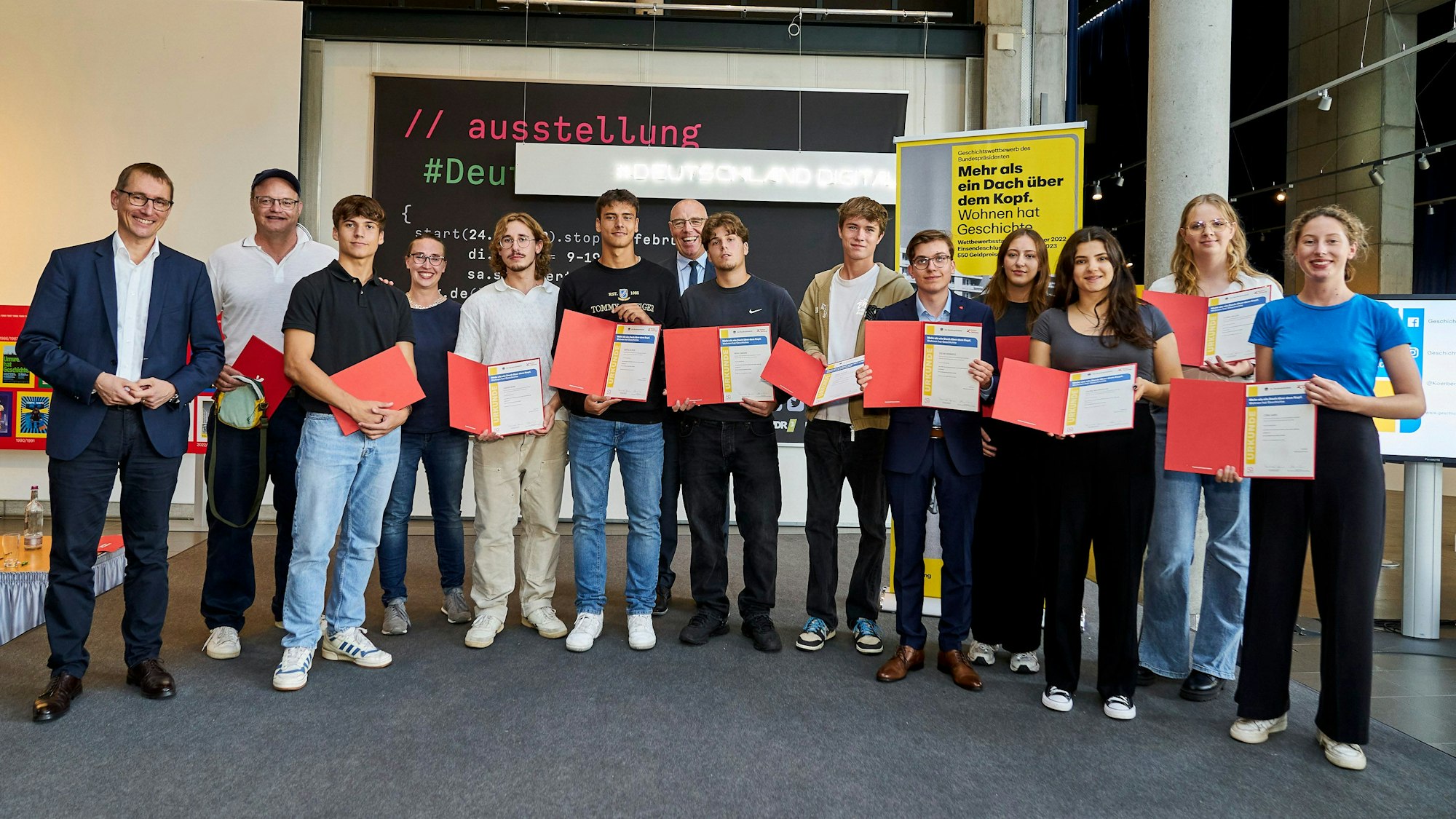 Eine Gruppe von Schülern und Lehrern mit Urkunden im Haus der Geschichte.