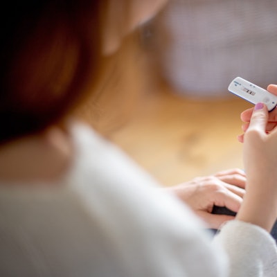 Symbolbild: Frau hält positiven Coronatest in der Hand.