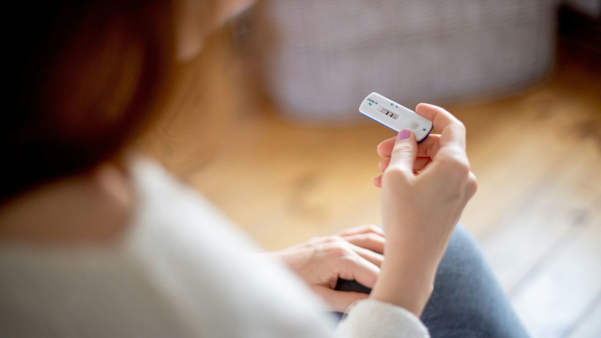 Symbolbild: Frau hält positiven Coronatest in der Hand.