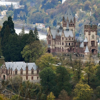 30.10.2018, Nordrhein-Westfalen, Königswinter: Schloss Drachenburg, aufgenommen vom Petersberg bei Königswinter aus, steht inmitten von herbstlich verfärbten Bäumen auf dem Drachenfels. Foto: Henning Kaiser/dpa