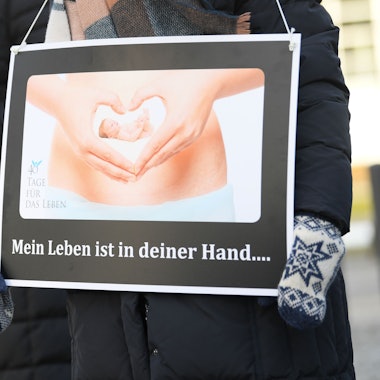 Hessen, Frankfurt am Main: Mit Plakaten mit der Aufschrift „Mein Leben ist in deiner Hand...“ und dem Bild eines 10 Wochen alten Embryo demonstrieren Abtreibungsgegner von der „Aktion SOS Leben“ vor der Beratungsstelle von Pro Familia. Ihr Protest richtet sich gegen die Schwangerschaftskonfliktberatung, die die Organisation in gesetzlichem Auftrag durchführt. Foto: Arne Dedert/dpa +++ dpa-Bildfunk +++ (Archivbild/Symbolbild)