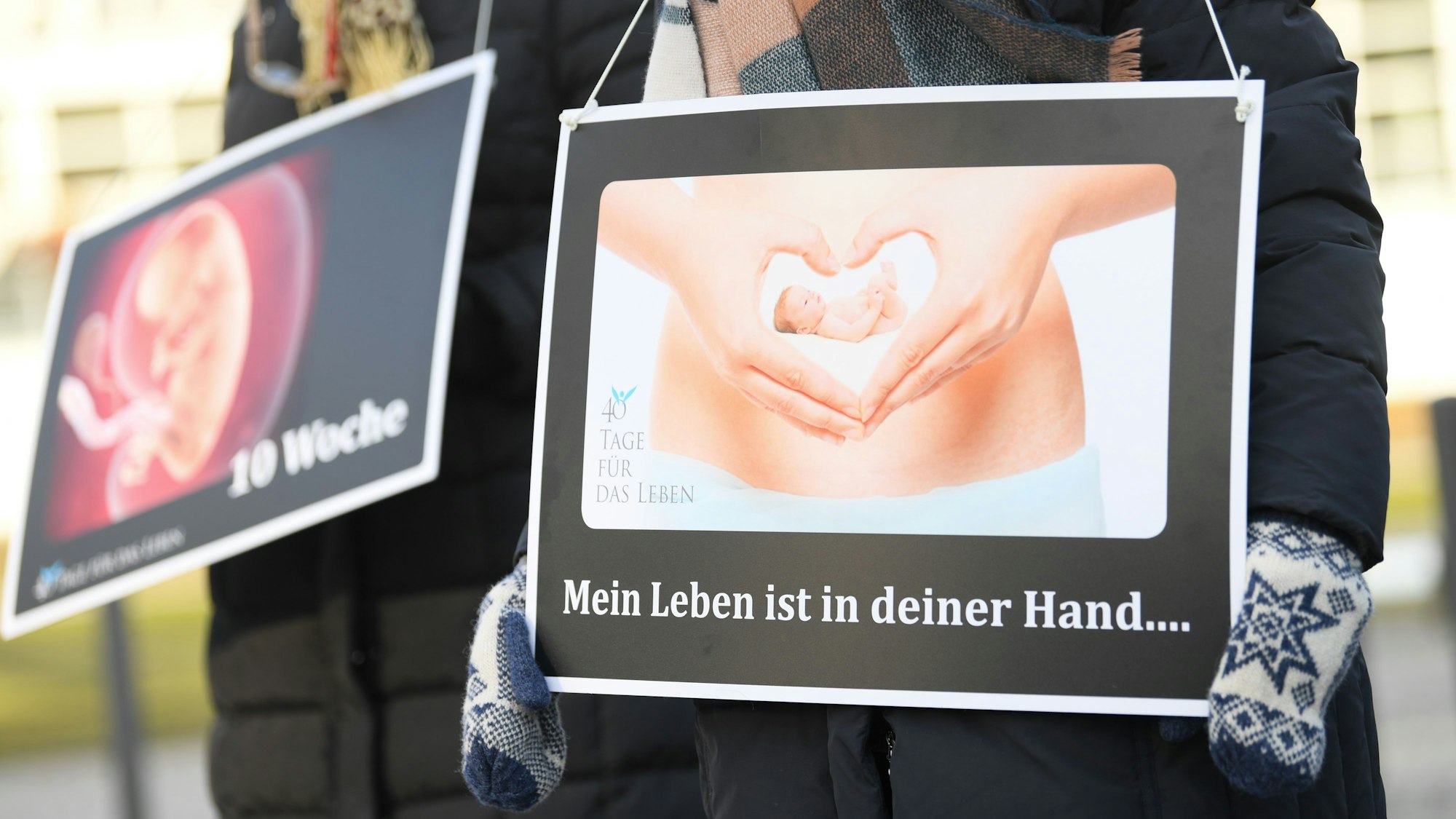 Hessen, Frankfurt am Main: Mit Plakaten mit der Aufschrift „Mein Leben ist in deiner Hand...“ und dem Bild eines 10 Wochen alten Embryo demonstrieren Abtreibungsgegner von der „Aktion SOS Leben“ vor der Beratungsstelle von Pro Familia. Ihr Protest richtet sich gegen die Schwangerschaftskonfliktberatung, die die Organisation in gesetzlichem Auftrag durchführt. Foto: Arne Dedert/dpa +++ dpa-Bildfunk +++ (Archivbild/Symbolbild)
