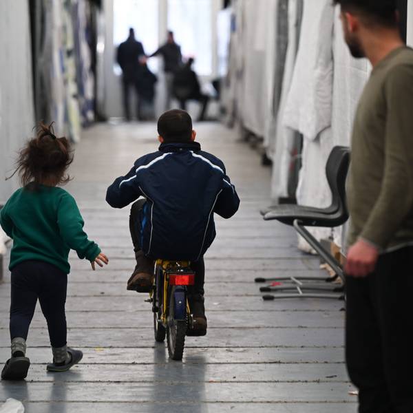 Flüchtlinge in Zelten, Wohncontainern und Turnhallen gehören auch in NRW längst wieder zur Realität. Ein kleiner Junge fährt auf einem Fahrrad zwischen Planen hindurch, ein kleines Mädchen eilt hinter ihm her.