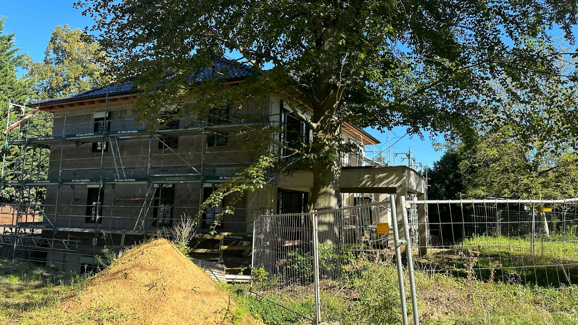 In einem Garten steht ein Rohbau.