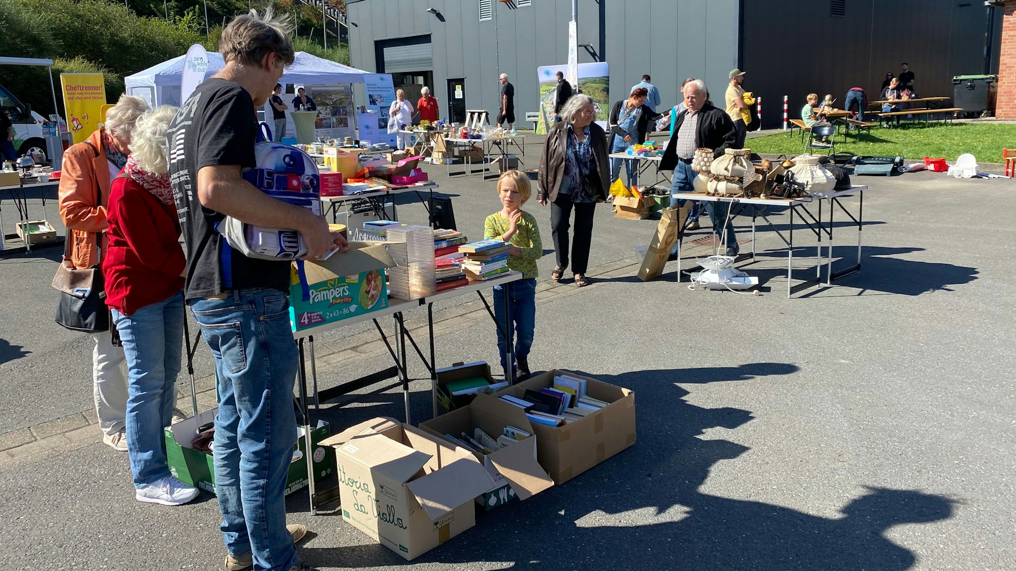 Auf Metabolon in Lindlar fand der Tauschrausch statt. Menschen schauen sich an verschiedenen Tischen um, an denen, wie auf einem Flohmarkt, Dinge angeboten wurden.