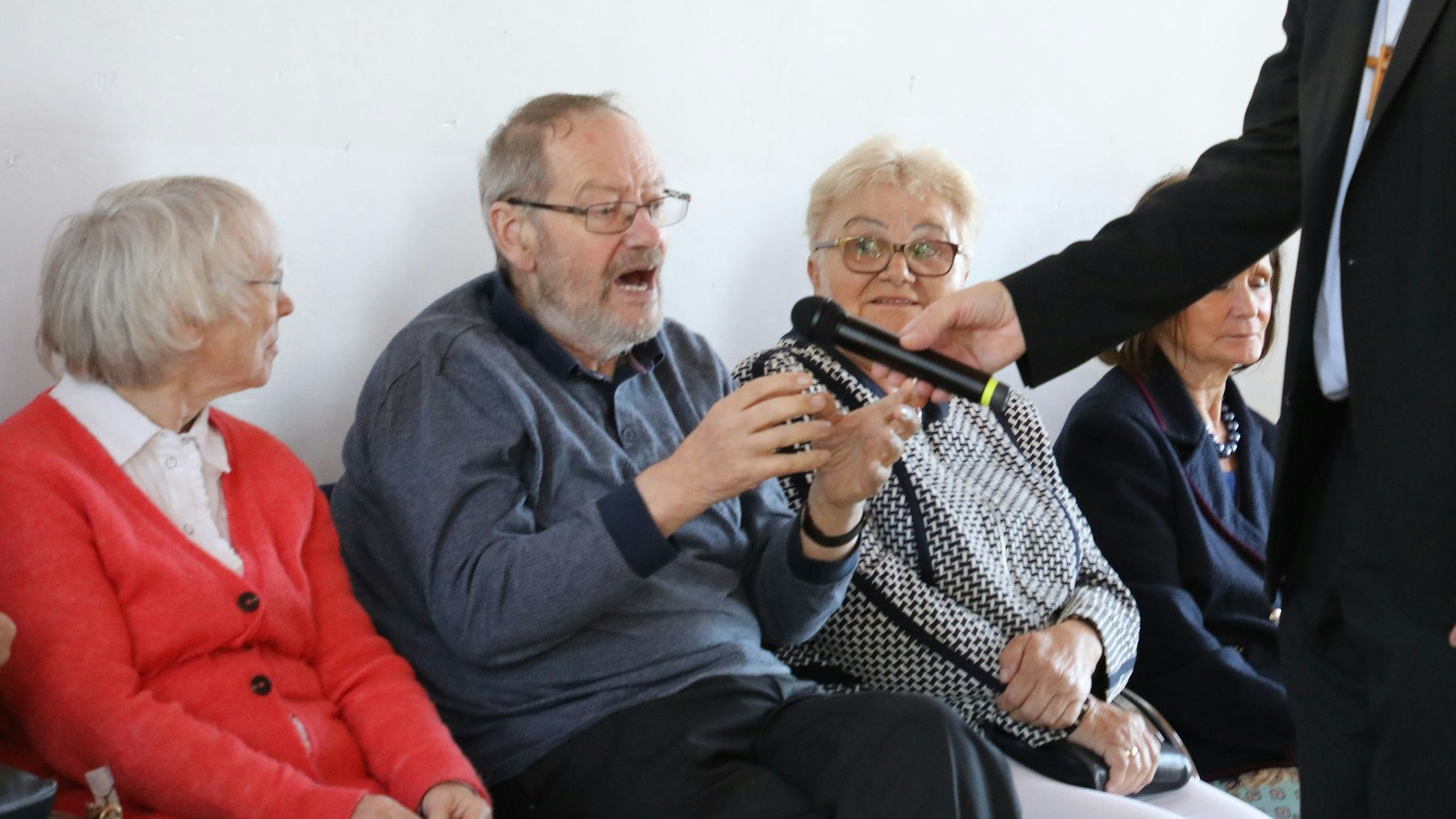 Weihbischof Ansgar Puff interview mit einem Mikrofon seinen Mitpriester Josef Rottländer.