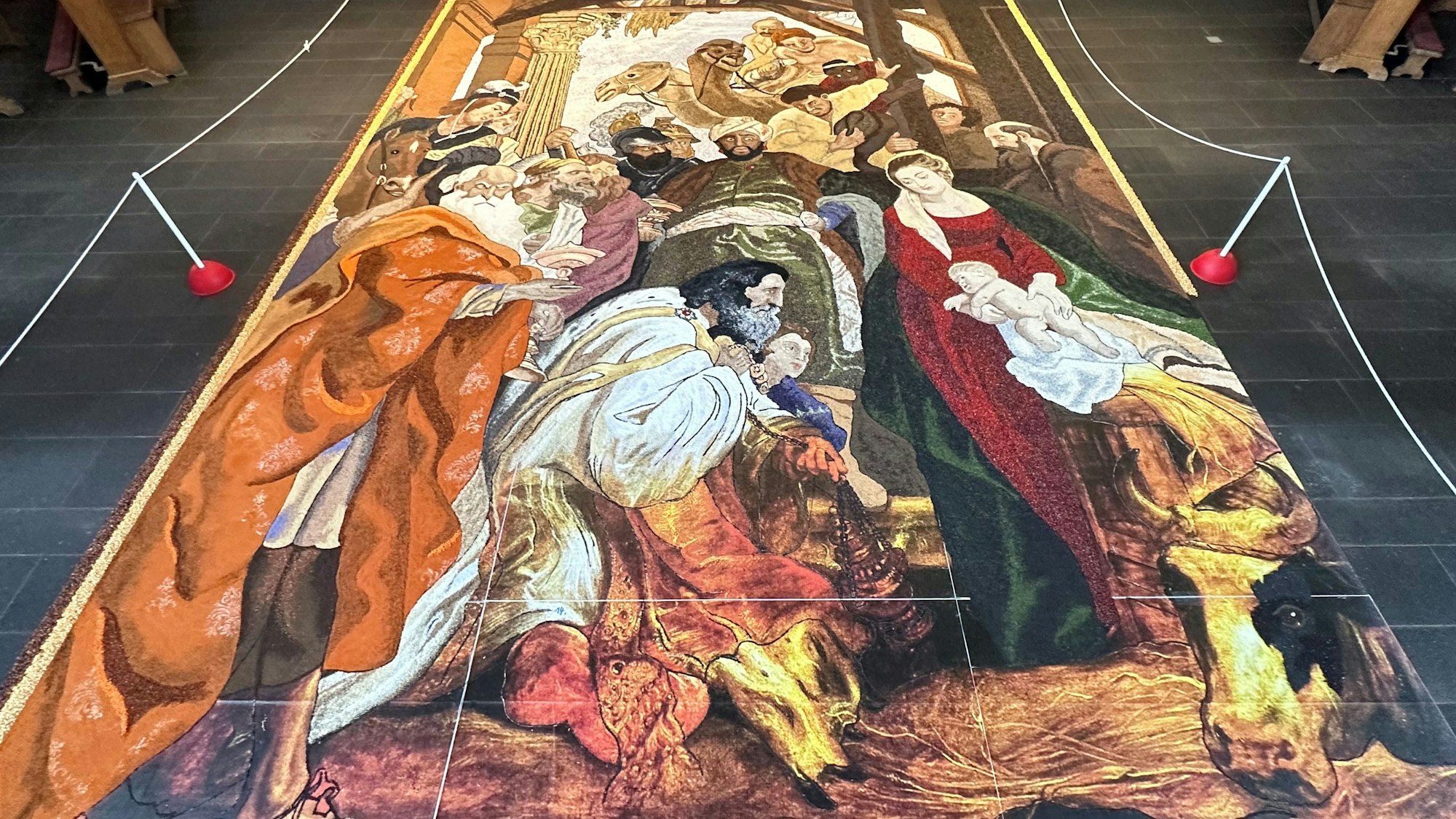 Auf dem Boden einer Kirche liegt das aus Körnern, Samen, Blüten und Hülsenfrüchten bestehende Erntedank-Bild.